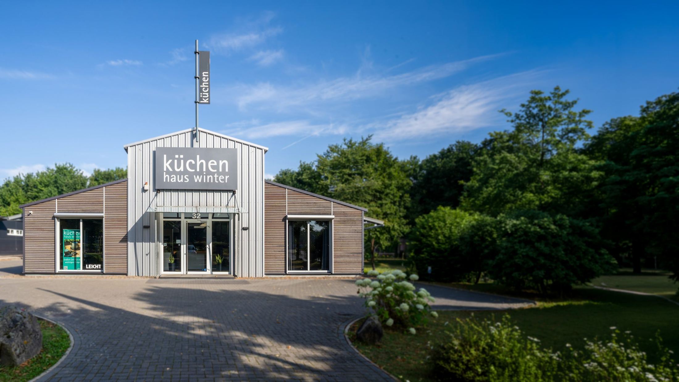 Außenansicht des Küchenstudios küchen haus winter in Kassel, umgeben von altem Baumbestand